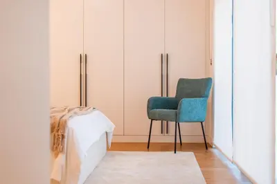 a bedroom with a blue chair and a bed at Suite Q - Supermarket - Pool - AC - Private Parking Spot in Funchal