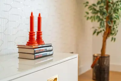 two red candles sitting on top of books on a dresser at Suite Q - Supermarket - Pool - AC - Private Parking Spot in Funchal
