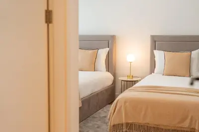 a bedroom with two beds and a table with a lamp at Suite Q - Supermarket - Pool - AC - Private Parking Spot in Funchal