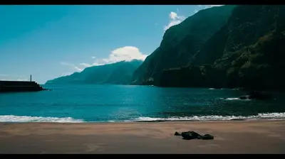 a person laying on the beach next to the water at Pôr do Sol I in Porto Moniz