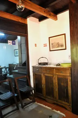 a dining room with a table and a wooden cabinet at Quinta O Refúgio in São Vicente