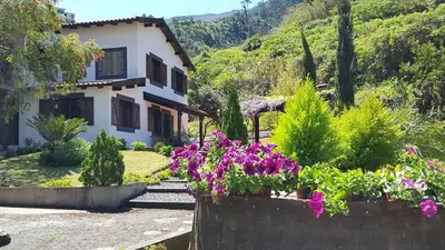 a house with flowers in front of it at Quinta O Refúgio in São Vicente