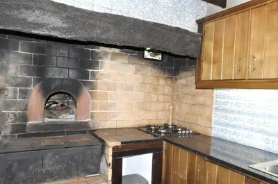 a kitchen with a brick wall with an oven at Quinta O Refúgio in São Vicente