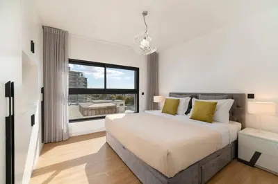 a bedroom with a large bed and a large window at São Lucas II by An Island Apart in Funchal