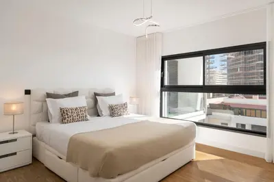 a white bedroom with a large bed and a window at São Lucas II by An Island Apart in Funchal