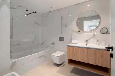 a white bathroom with a tub and a toilet and a sink at São Lucas II by An Island Apart in Funchal