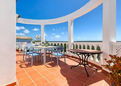 a patio with tables and chairs and a view of the ocean at Arrifana Ocean View Villa in Aljezur