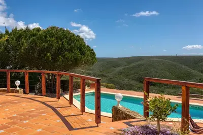 a view of a swimming pool from the deck of a house at Arrifana Ocean View Villa in Aljezur
