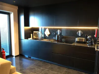 a kitchen with black walls and a counter with sinks at Heaven and Sea in Madeira in Funchal