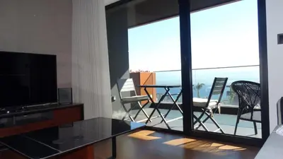 a living room with a television and a table and chairs at Heaven and Sea in Madeira in Funchal
