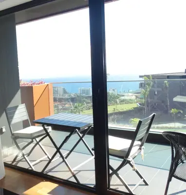 a table and chairs on a balcony with a view of the ocean at Heaven and Sea in Madeira in Funchal
