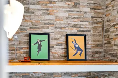 a brick wall with three framed pictures on a shelf at Matur Place in Machico in Machico