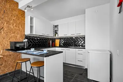 a kitchen with white cabinets and a counter with stools at Matur Place in Machico in Machico