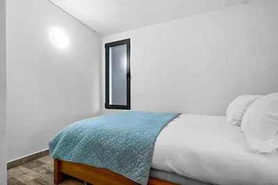 a bedroom with a bed with a blue blanket on it at Matur Place in Machico in Machico