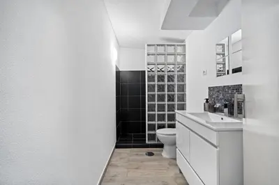 a white bathroom with a toilet and a sink at Matur Place in Machico in Machico