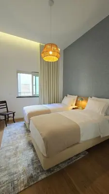 a bedroom with two beds and a chandelier at Urban Funchal Charming Apartment in Funchal