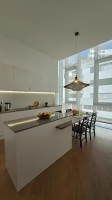 a kitchen with a table and chairs and a large window at Urban Funchal Charming Apartment in Funchal