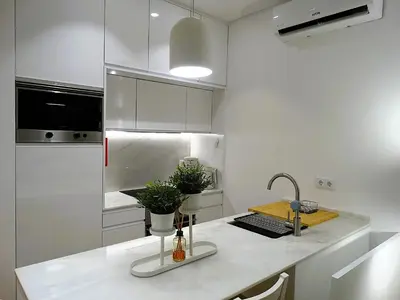 a white kitchen with a sink and a counter top at CA Tanoeiros 1 in Funchal