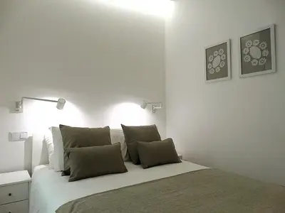 a bedroom with a bed with two lights on the wall at CA Tanoeiros 1 in Funchal