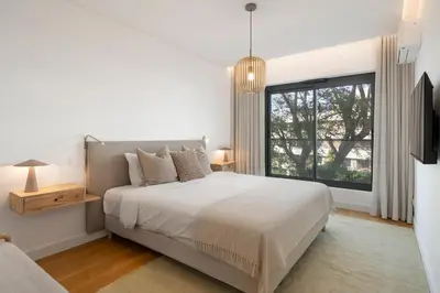 a white bedroom with a large bed and a window at Acqua Residence I by An Island Apart in Funchal