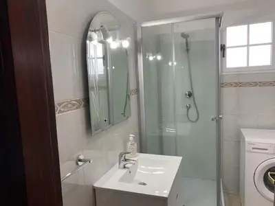a bathroom with a sink and a shower with a mirror at Quinta da Colina in São Vicente