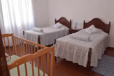 a bedroom with two beds and a staircase at Quinta da Colina in São Vicente