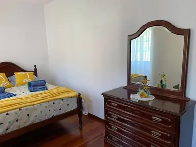 a bedroom with a bed and a dresser with a mirror at Quinta da Colina in São Vicente