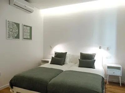 a bedroom with a bed with two green pillows at CA Tanoeiros 2 in Funchal