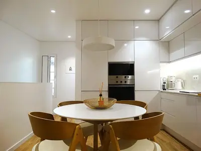 a kitchen and dining room with a white table and chairs at CA Tanoeiros 2 in Funchal