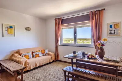 a living room with a couch and a table at Apartamento Branco Beliche in Sagres