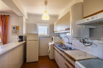 a kitchen with a sink and a refrigerator at Apartamento Branco Beliche in Sagres