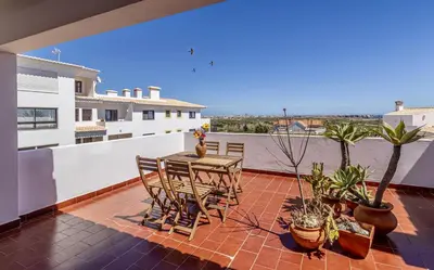 a patio with a table and chairs on a balcony at Apartamento Branco Beliche in Sagres