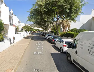 a street with cars parked on the side of the road at Pipoca in Luz