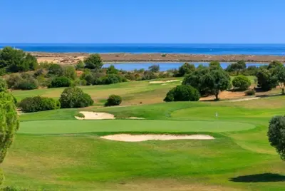 a view of a golf course with the ocean in the background at Pipoca in Luz