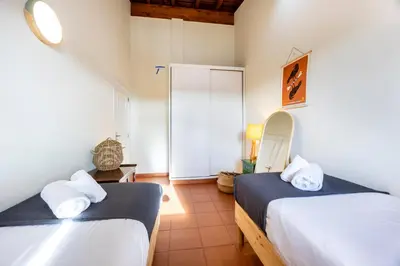 a bedroom with two beds and a mirror and a door at Casa Arafel in Aljezur