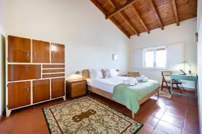 a bedroom with a bed and a desk in a room at Casa Arafel in Aljezur
