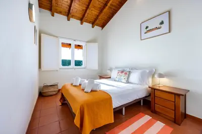 a bedroom with a bed with a orange blanket at Casa Arafel in Aljezur