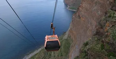 a cable car flying over a body of water at Excellent Holiday Apartment in Caniço