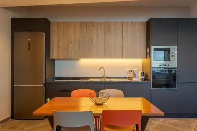 a kitchen with a wooden table and orange chairs at A Porta das Neves in Funchal