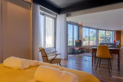 a bedroom with a bed and a living room with a desk at A Porta das Neves in Funchal