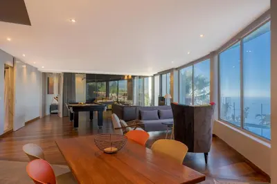 a living room with a couch and a table and chairs at A Porta das Neves in Funchal