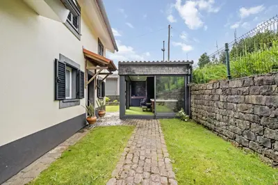 a house with a stone wall and a courtyard at Casa do Santo by Homie in Santo da Serra