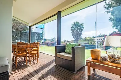 an open living room with glass walls and a table at Casa do Santo by Homie in Santo da Serra