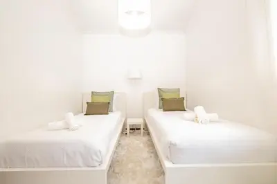 two beds in a room with white walls at Casa do Santo by Homie in Santo da Serra