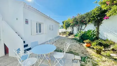 a patio with a table and chairs next to a building at CasaÂncora - Sea View Rooftop - 1km Beach - Garden in Raposeira
