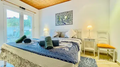 a bedroom with a bed and a large window at CasaÂncora - Sea View Rooftop - 1km Beach - Garden in Raposeira