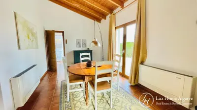 a dining room with a wooden table and chairs at CasaÂncora - Sea View Rooftop - 1km Beach - Garden in Raposeira