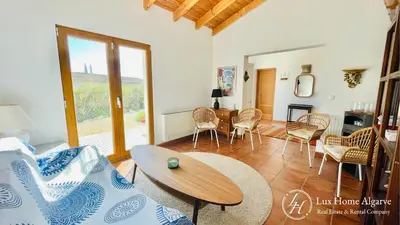 a living room with a table and chairs at CasaÂncora - Sea View Rooftop - 1km Beach - Garden in Raposeira