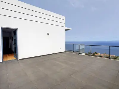 a white house with a balcony overlooking the ocean at Rising Sun Villa in Gaula