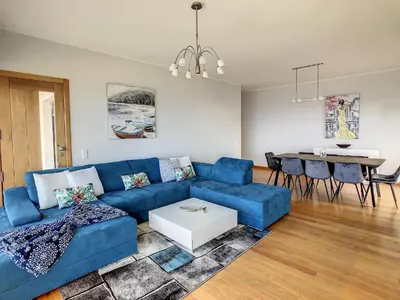 a living room with a blue couch and a table at Rising Sun Villa in Gaula